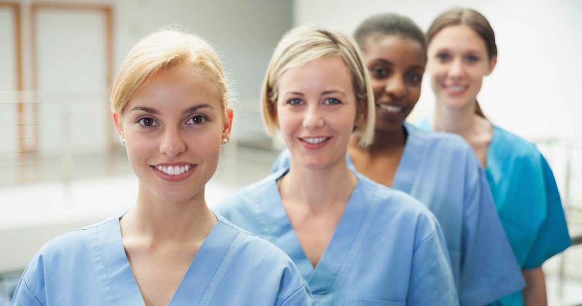 Female nurse looking at camera in hospital hallway